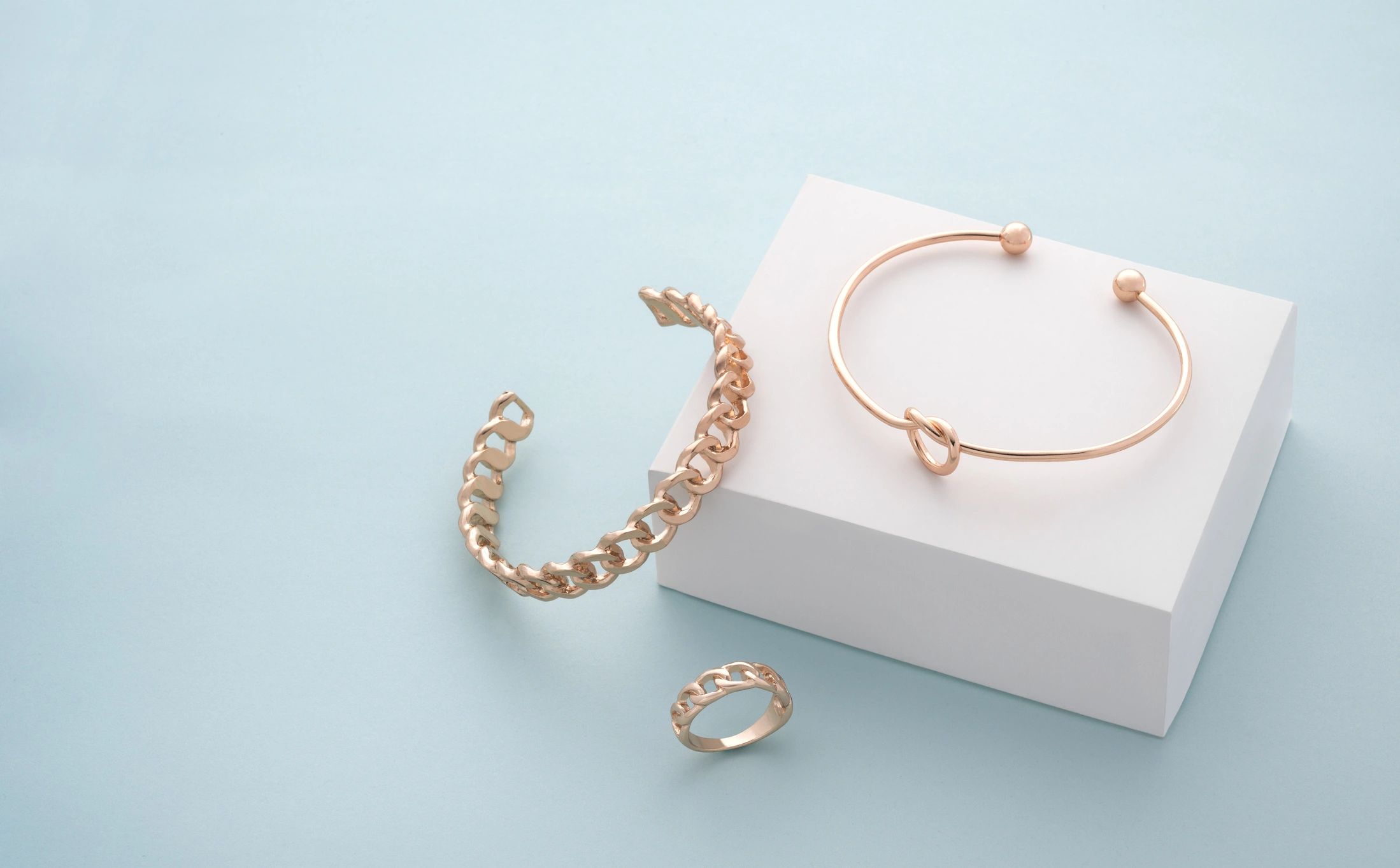 Minimal jewelry arranged on a clean background with copy space.